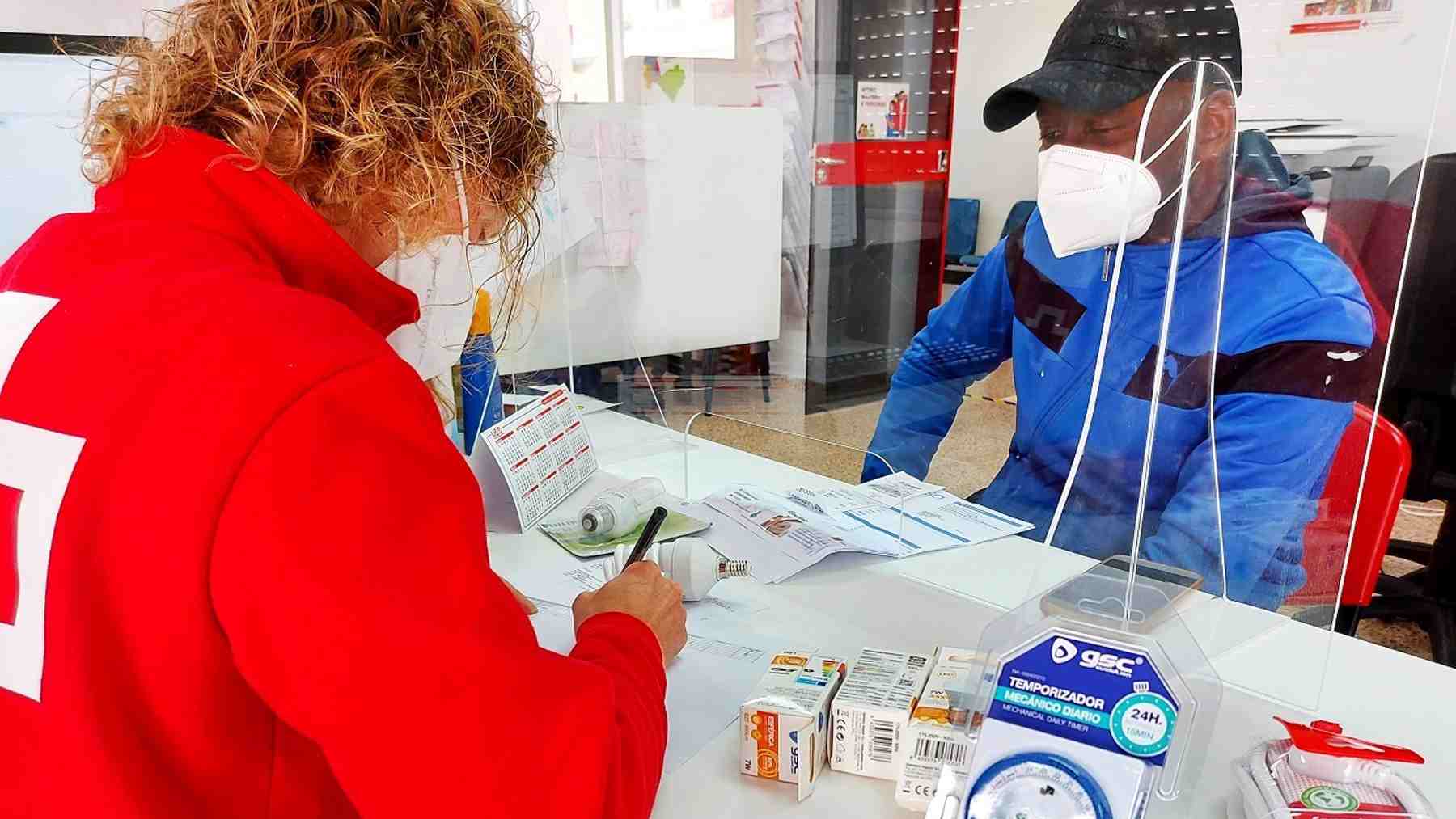 Una voluntaria de Cruz Roja ofrece información para ahorrar en la factura de la luz a familias vulnerables. Foto: Endesa