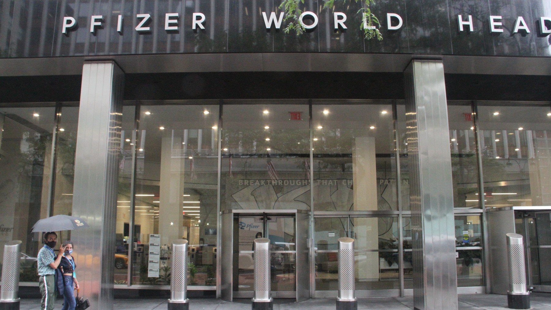 Varias personas caminan en Nueva York frente a la sede de Pfizer.