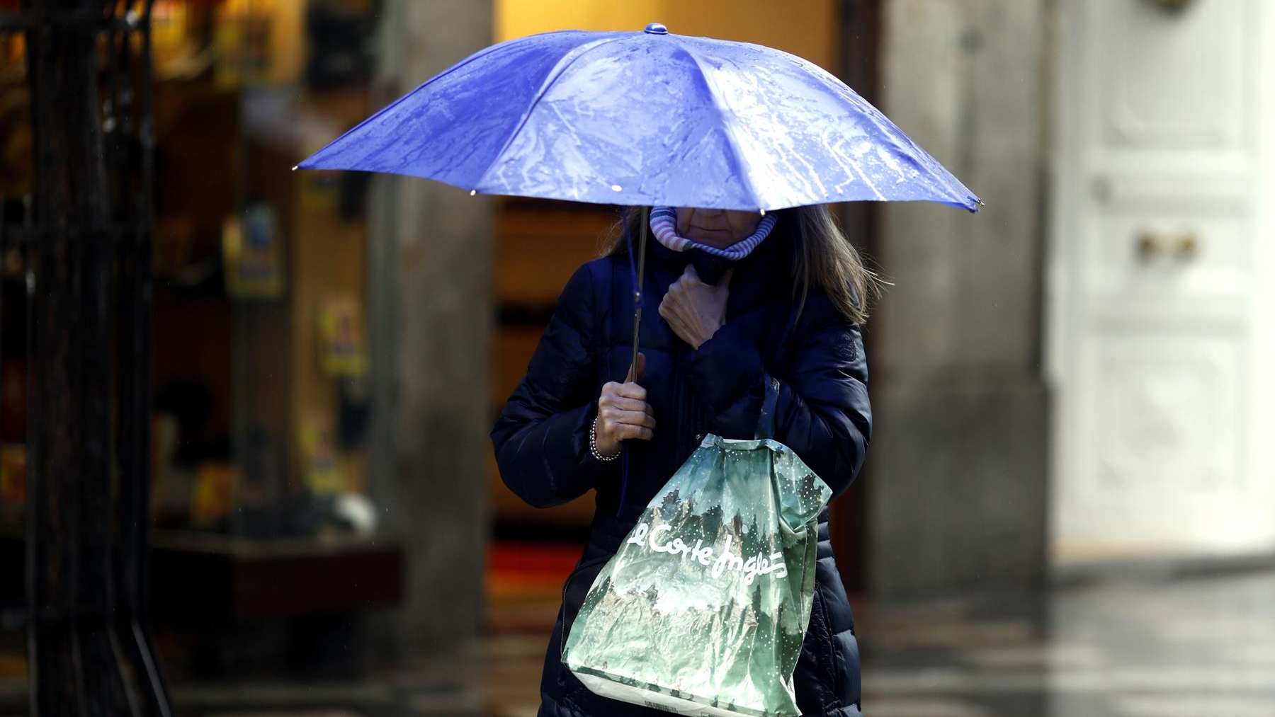 Una mujer pasea abrigada y con paraguas. EUROPA PRESS