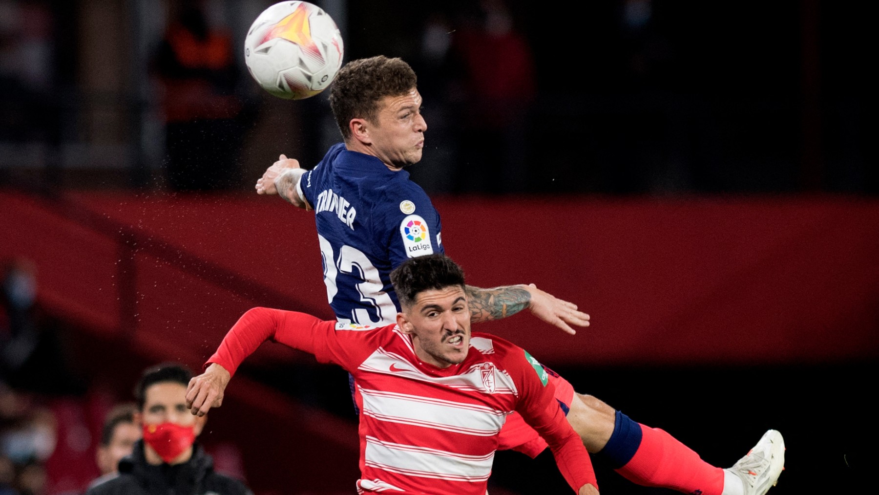 Trippier y Neva disputan un balón en el Granada – Atlético. (AFP)