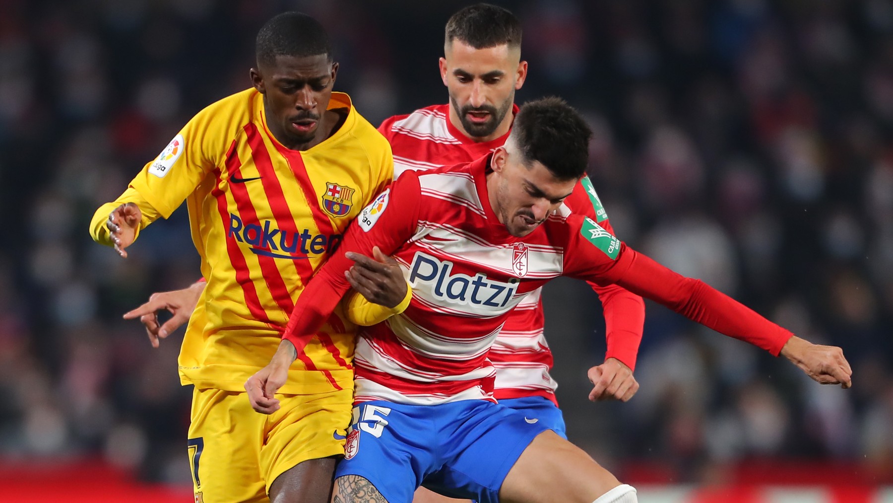 Dembélé y Neva pelean por un balón.