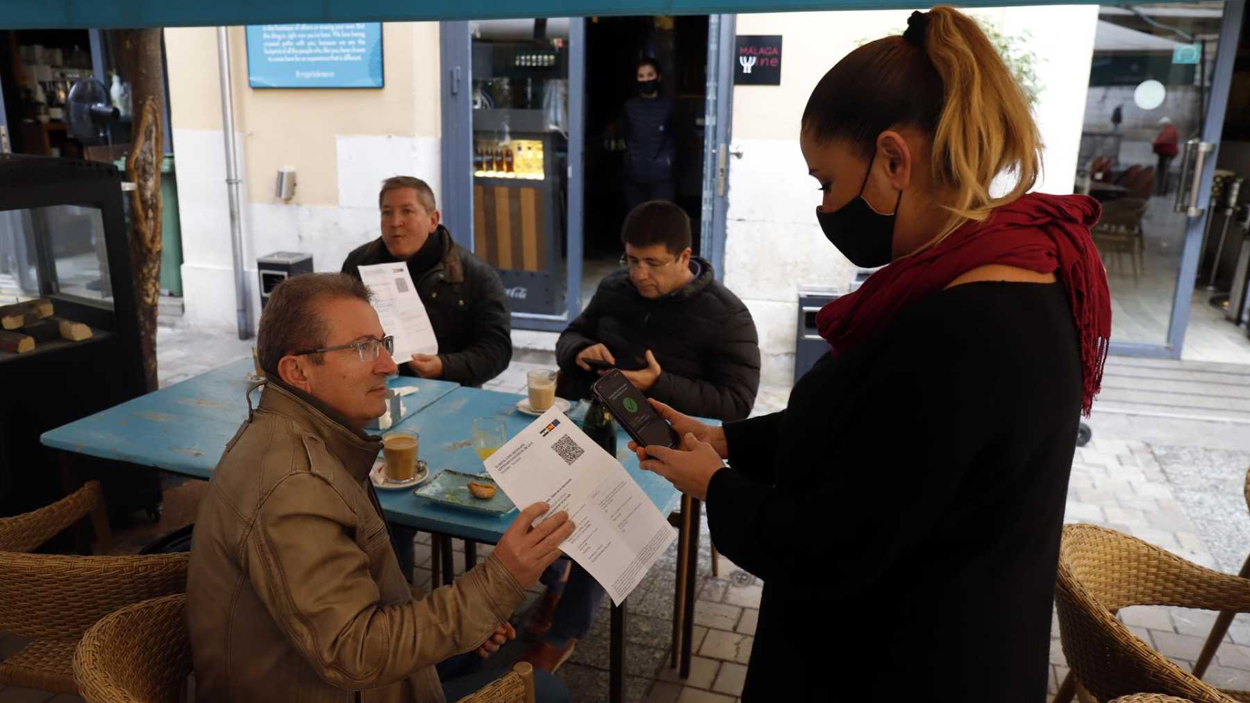 Una camarera pide certificado a los clientes en una mesa en la terraza de un bar. -Foto: Álex Zea – Europa Press.