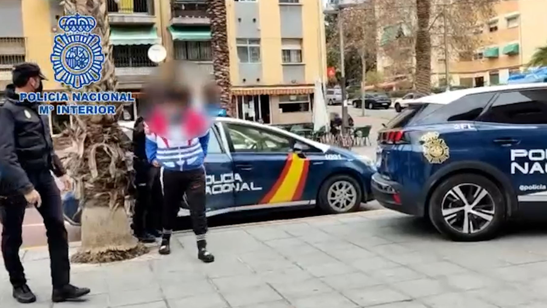 El detenido, escoltado por dos policías nacionales, ante la Comisaría.