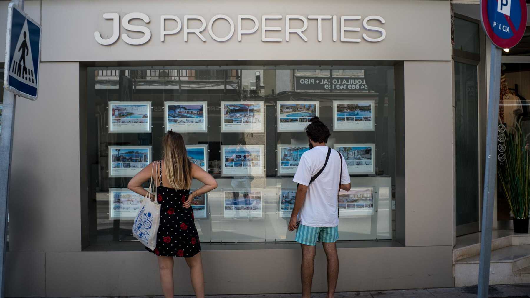 Dos personas observan inmuebles en alquiler y en venta en un escaparate de una inmobiliaria ubicada en Palma. Foto: Europa Press / Matias Chiofalo.