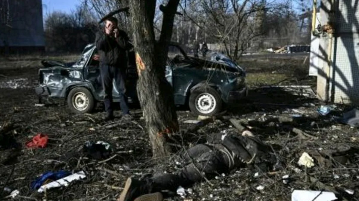 Un hombre observa a un hombre abatido en Ucrania.