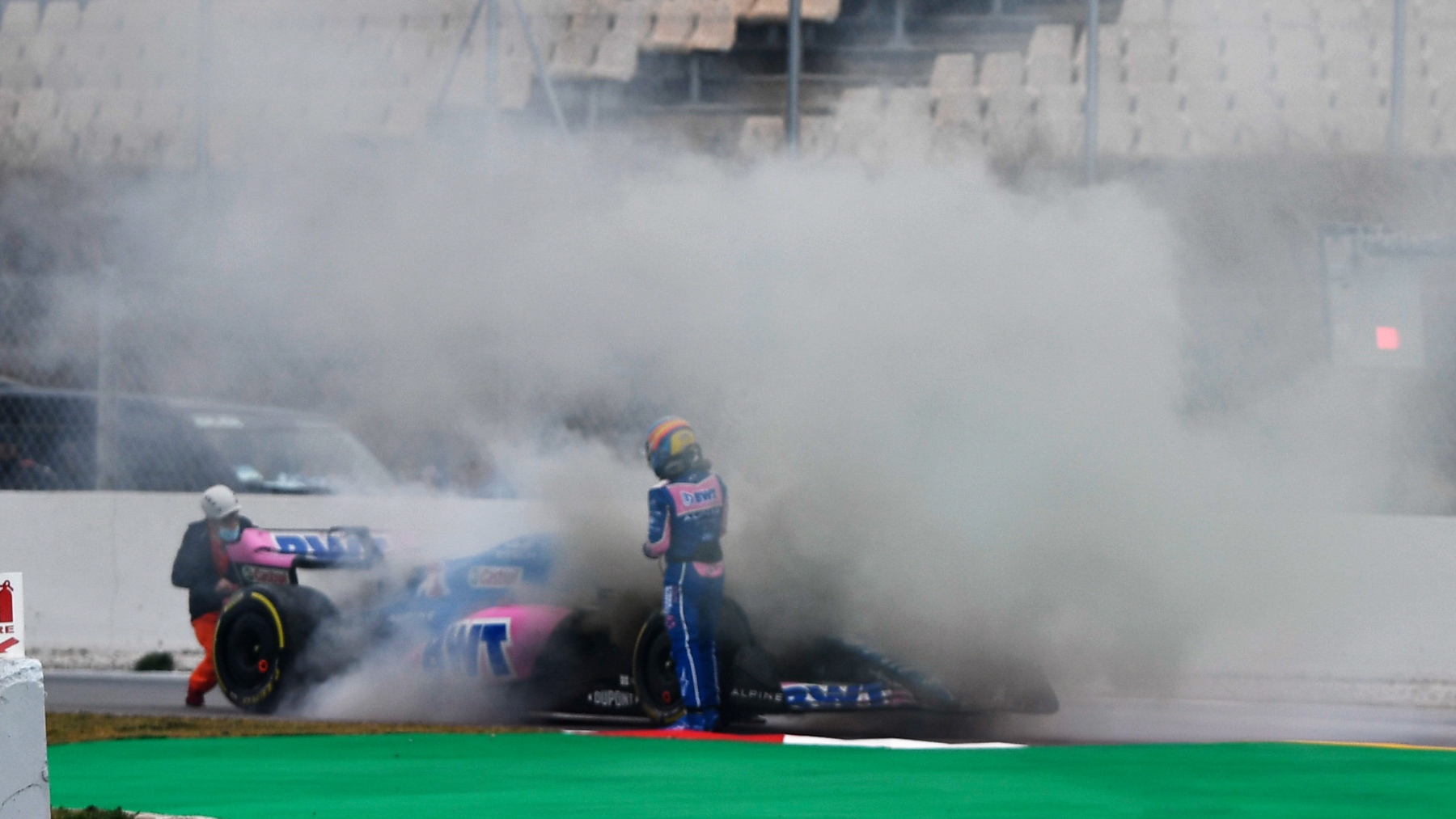 Fernando Alonso junto a su coche envuelto en humo. (Getty)