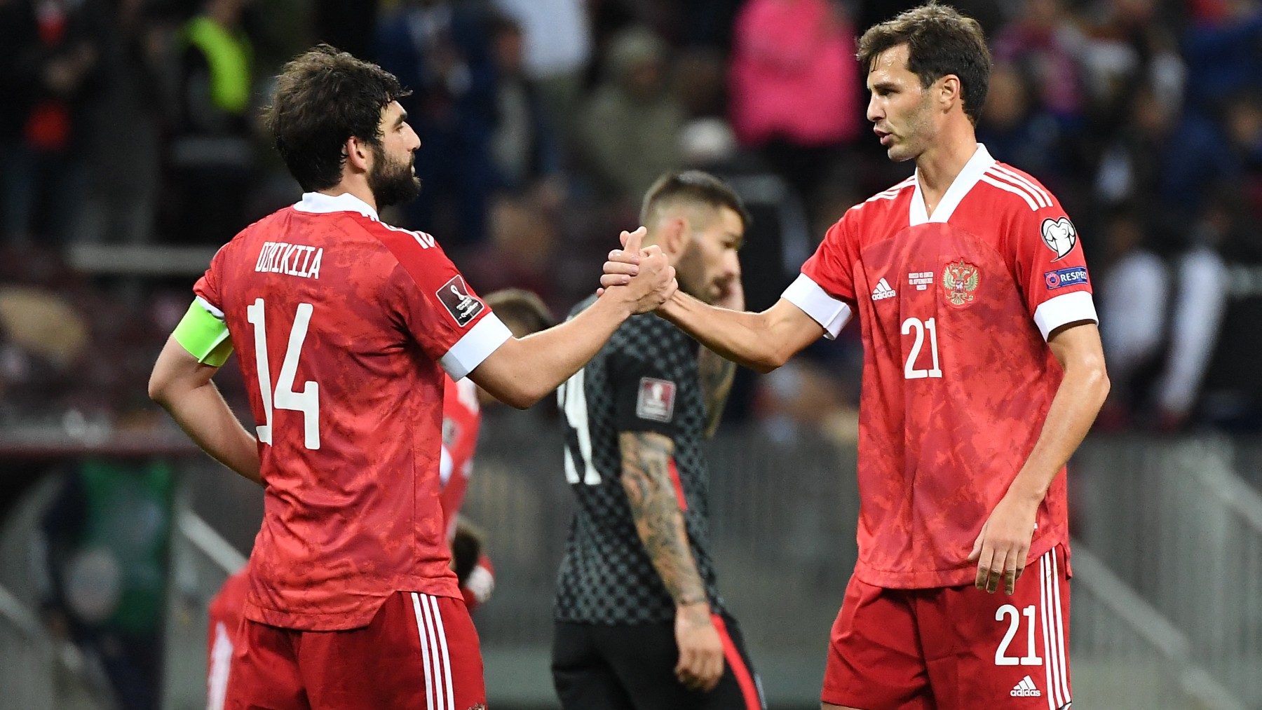 Dzhikiya y Erokhin se saludan durante un partido de la selección rusa con la camiseta de Adidas. (AFP)