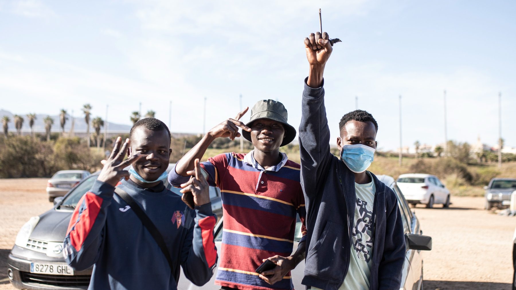 Inmigrantes subsaharianos hacen el signo de la victoria tras conseguir saltar la valla de Melilla (ILIES AMAR / EUROPA PRESS).