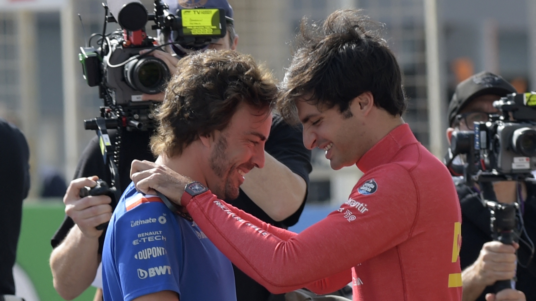 Fernando Alonso y Carlos Sainz se saludan en Bahrein. (AFP)