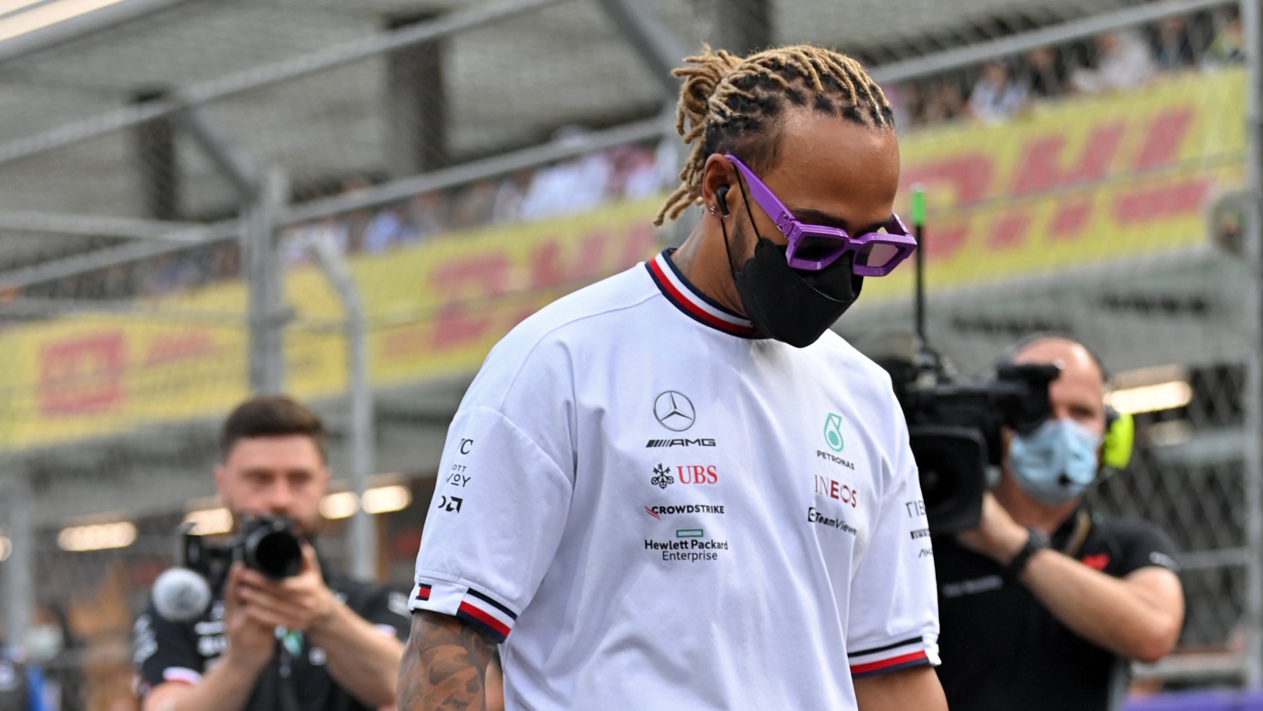 Lewis Hamilton camina cabizbajo en un circuito. (AFP)