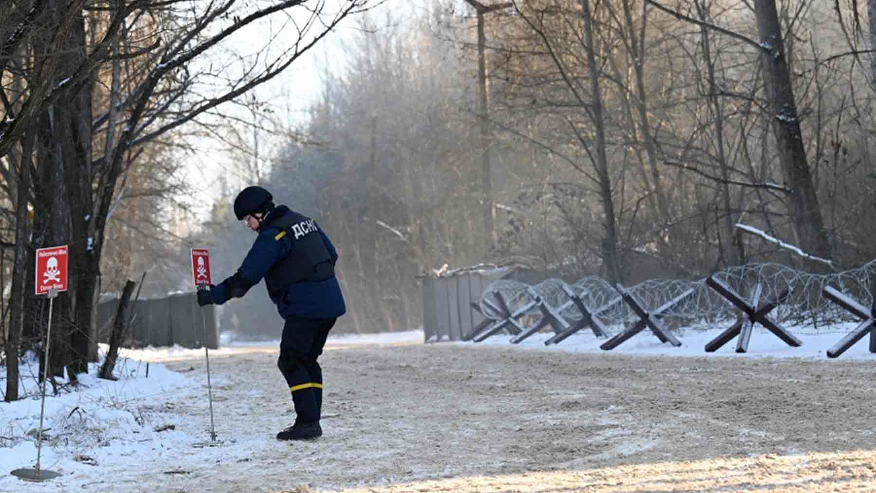 Un soldado ruso sin protección coloca una marca de zona radiactiva en Chernóbil. (AFP)