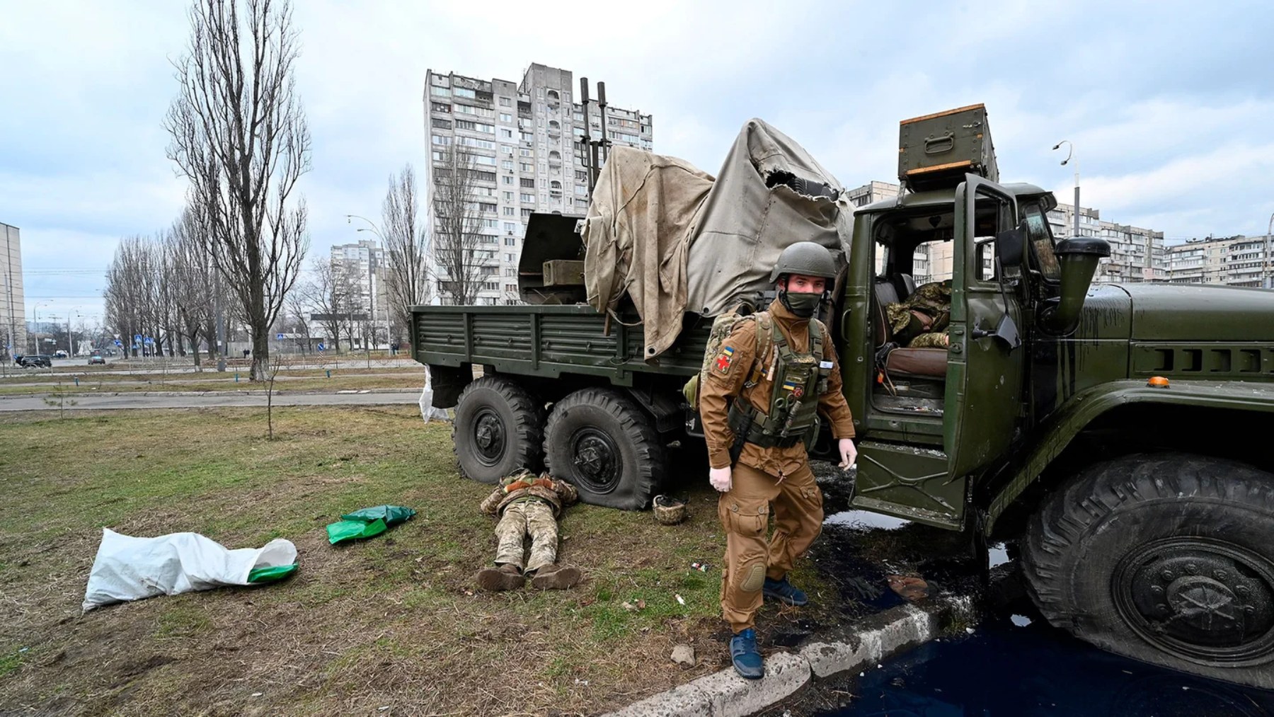 Un médico militar ucraniano tras examinar el cuerpo de un militar ruso que vestía uniforme ucraniano.(AFP)