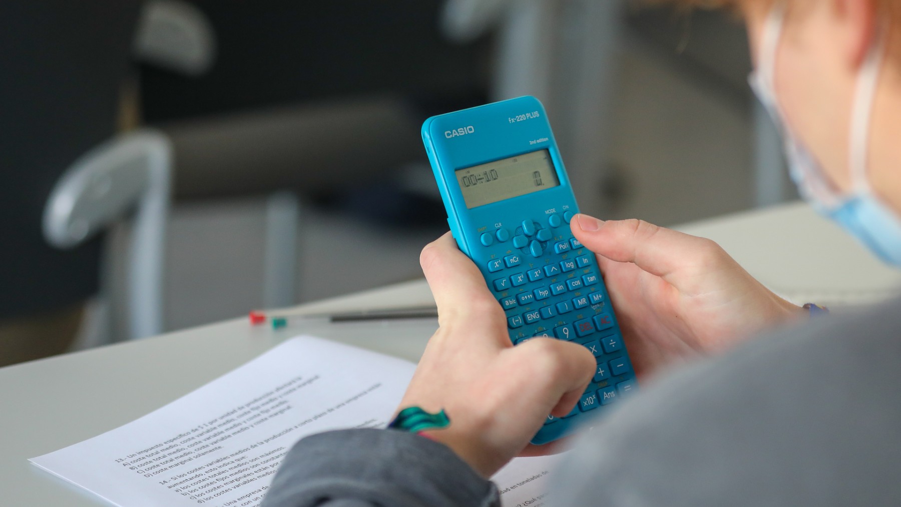 Un alumno con una calculadora en clase de matemáticas.