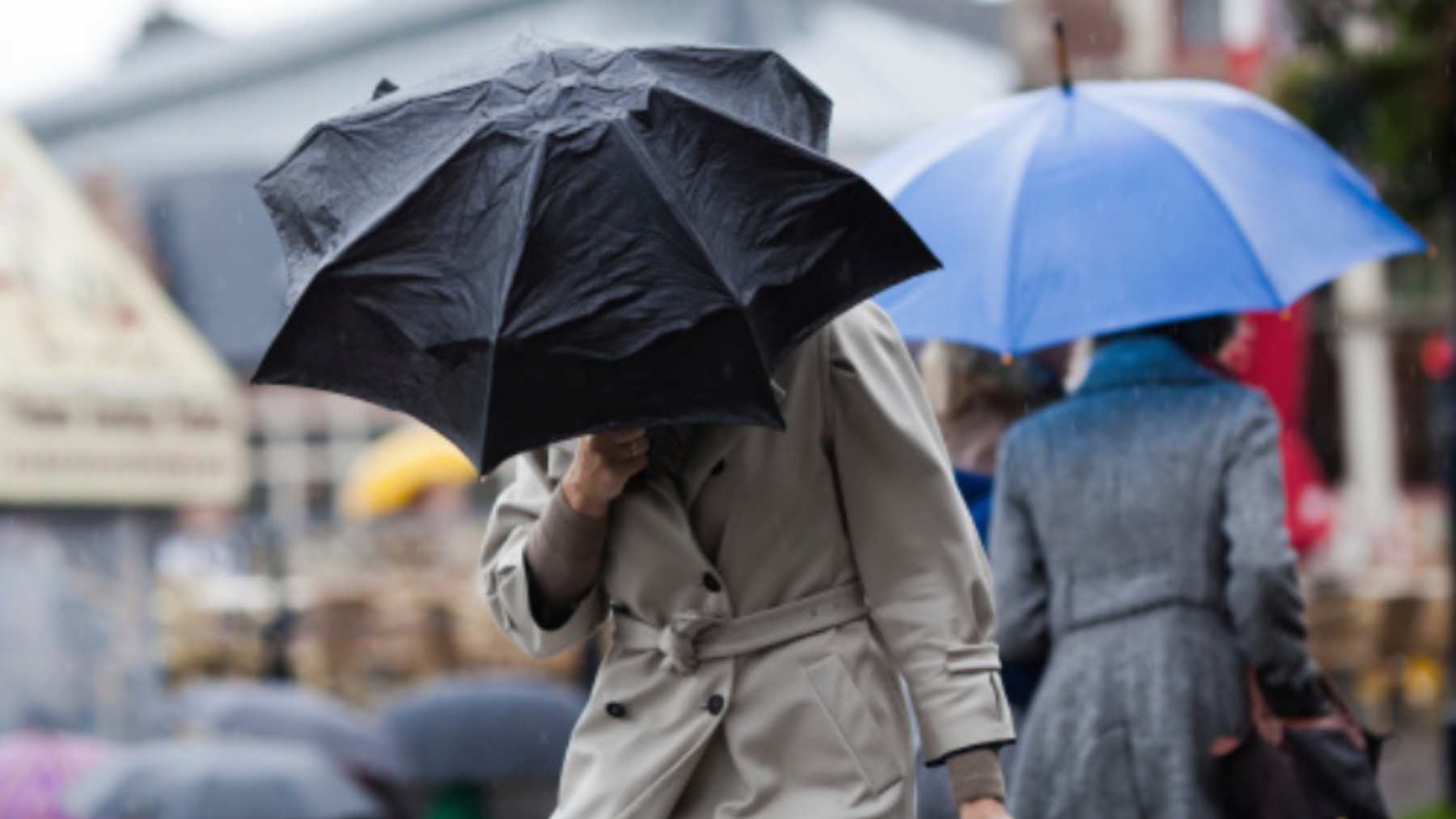 Varias personas cubriéndose bajo un paraguas