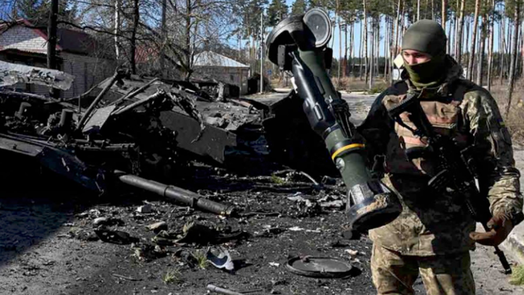 Un soldado ucraniano posa junto a un carro ruso destruido.