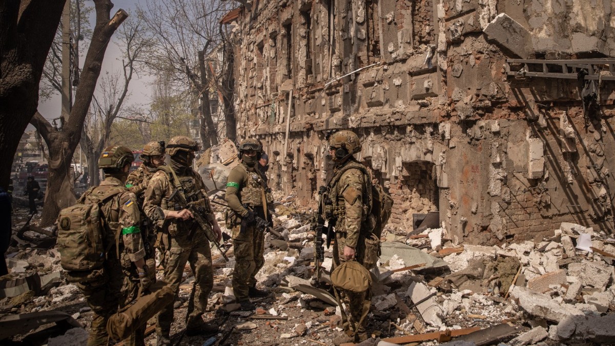 Miembros del ejército ucraniano caminan entre los escombros después alcanzar misiles, una ciudad.