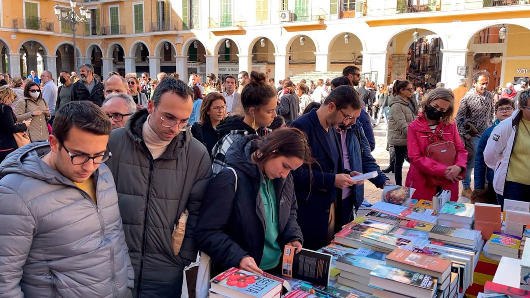 Ciudadanos en las paradas de libros instaladas en la Plaza Mayor de Palma.
