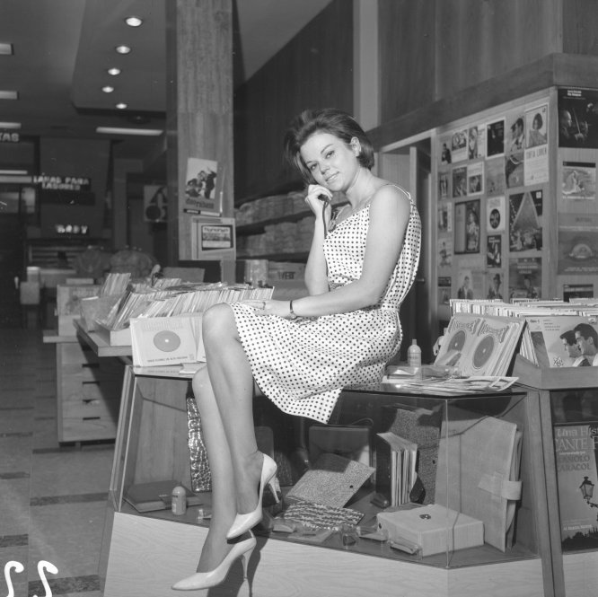Una modelo con un vestido de verano en el espacio dedicado a la música en los almacenes Simeón. Madrid, 1963. @Cristóbal Portillo @Archivo Regional de la CAM