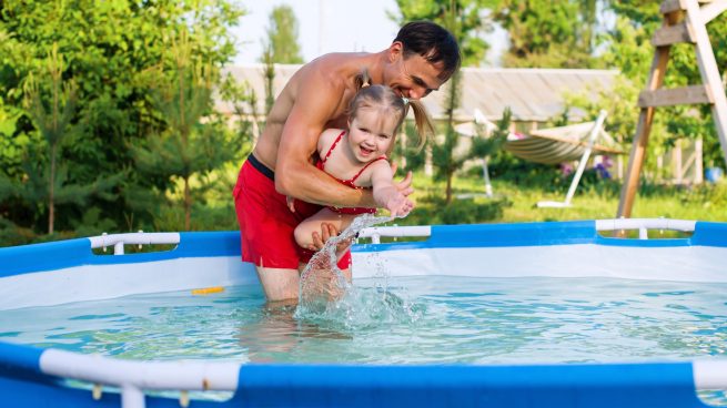 Padre e hija jugando en la piscina