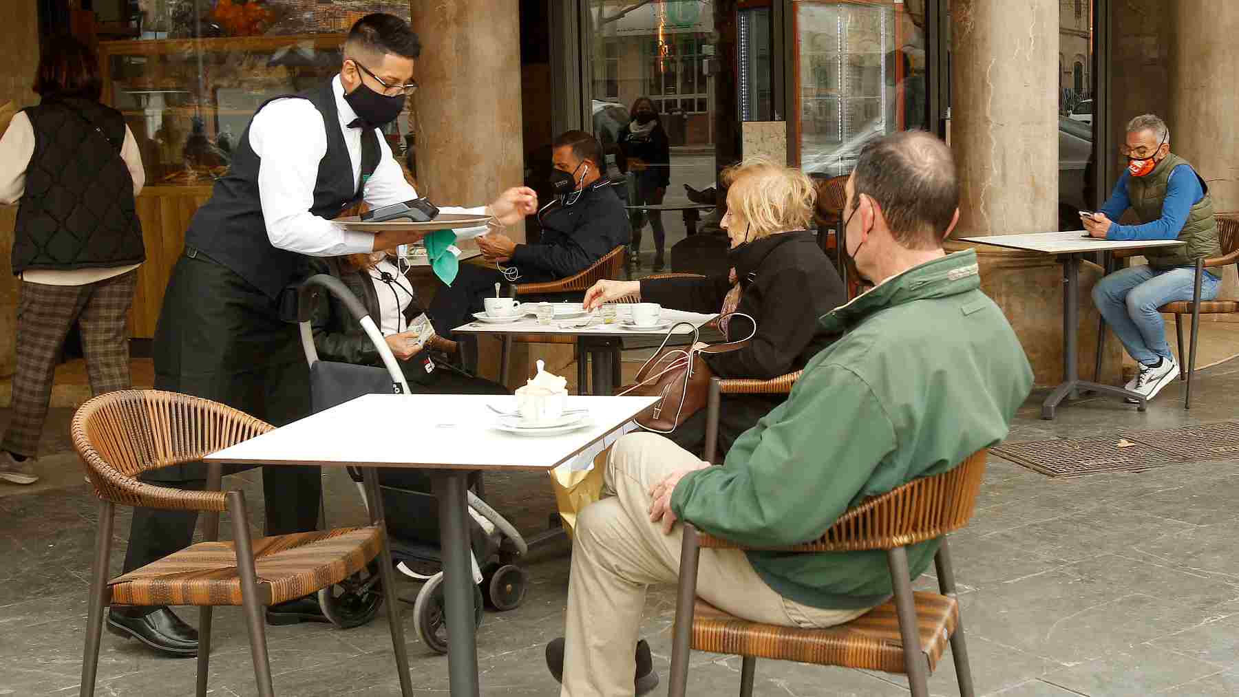 Un camarero atiende a varios clientes en la terraza de un bar en Palma. – Isaac Buj – Europa Press