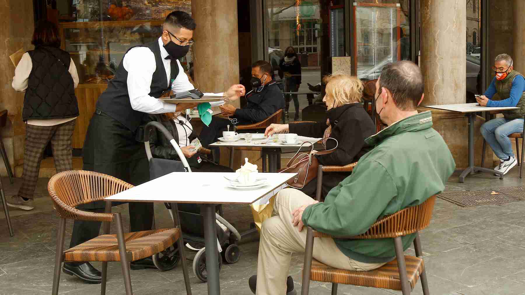 Un camarero atiende a varios clientes en la terraza de un bar en Palma. – Isaac Buj – Europa Press