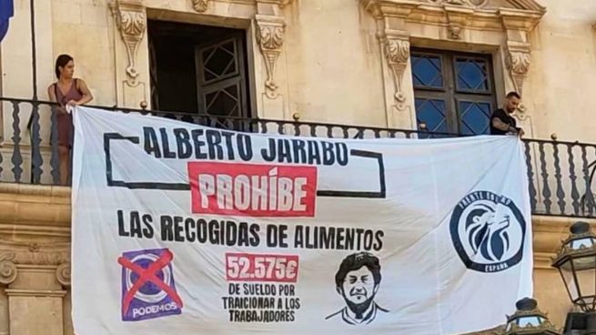 Dos activistas de Frente Obrero colocando la pancarta.