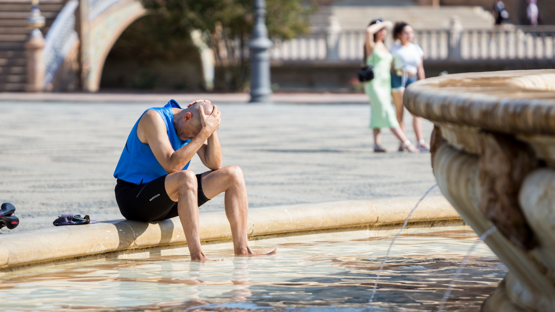 Un hombre se refresca en la Plaza de España de Sevilla en plena ola de calor (DANIEL GONZÁLEZ ACUNA / DPA).