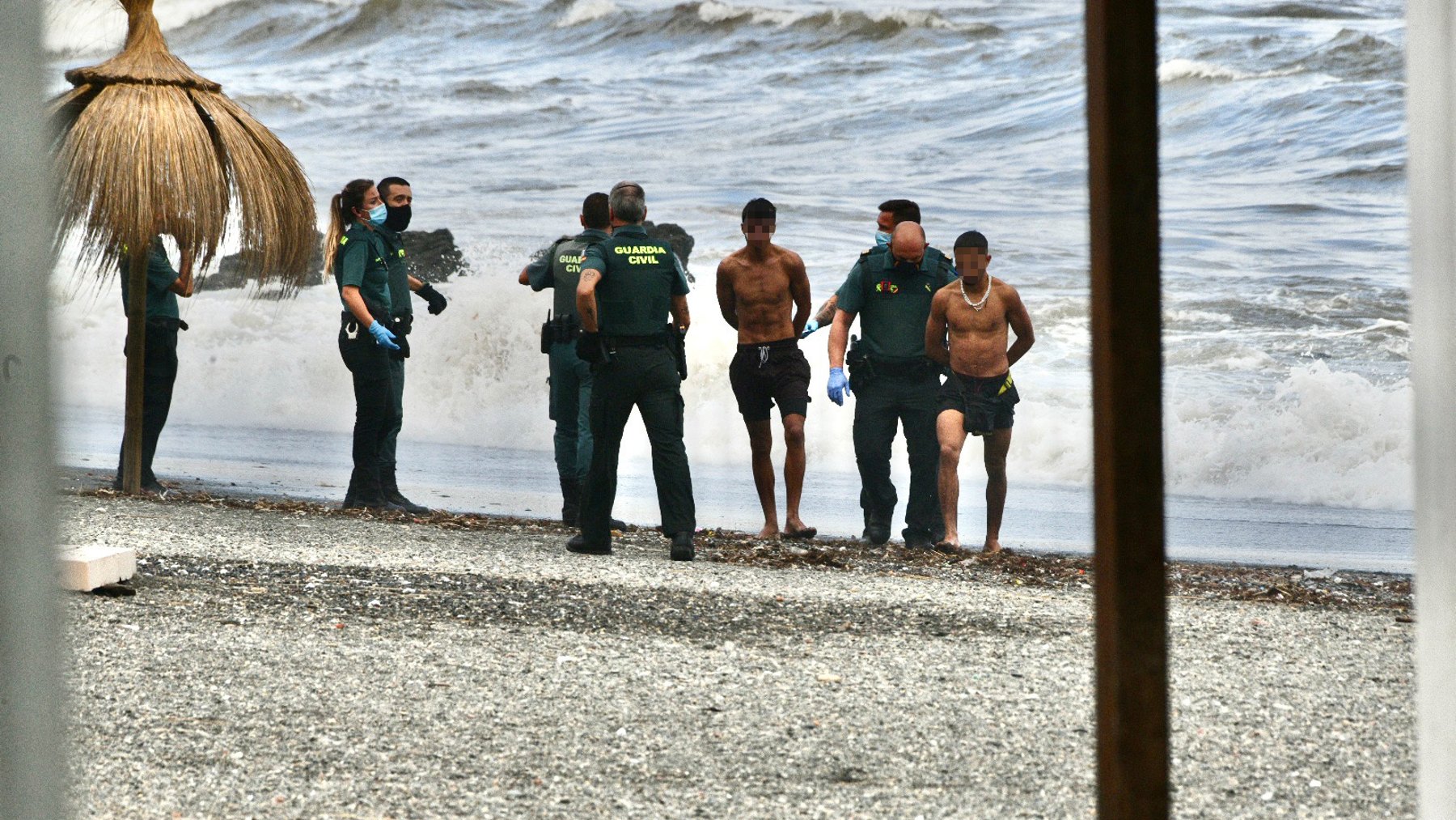 Agentes de la Guardia Civil arrestan a inmigrantes ilegales marroquíes en la playa del Tarajal, en Ceuta (EUROPA PRESS).
