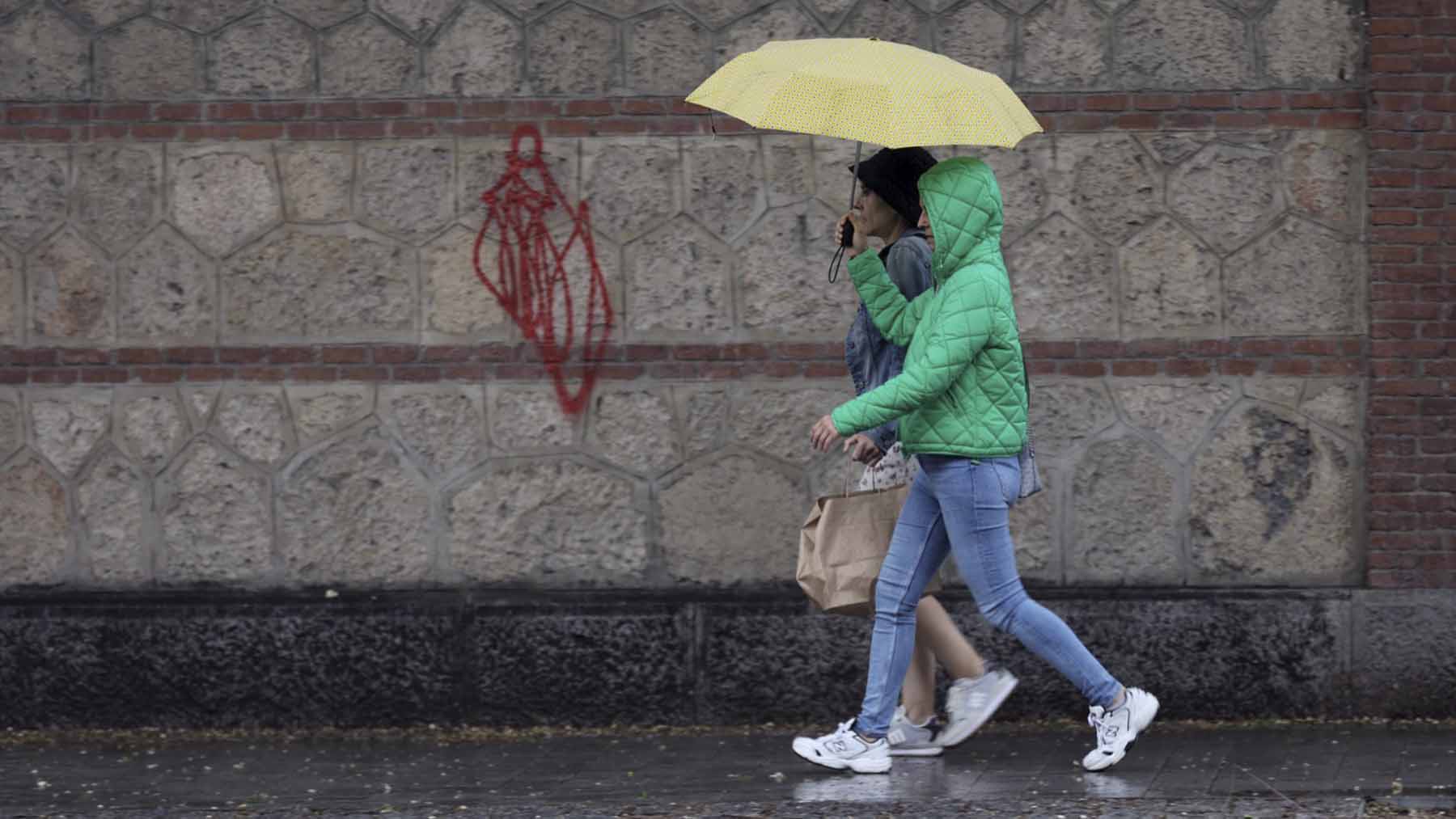 Dos mujeres caminan bajo la lluvia en Madrid. (EP)