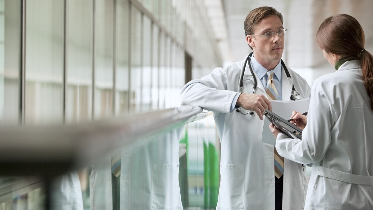 Varios médicos en un pasillo de hospital.