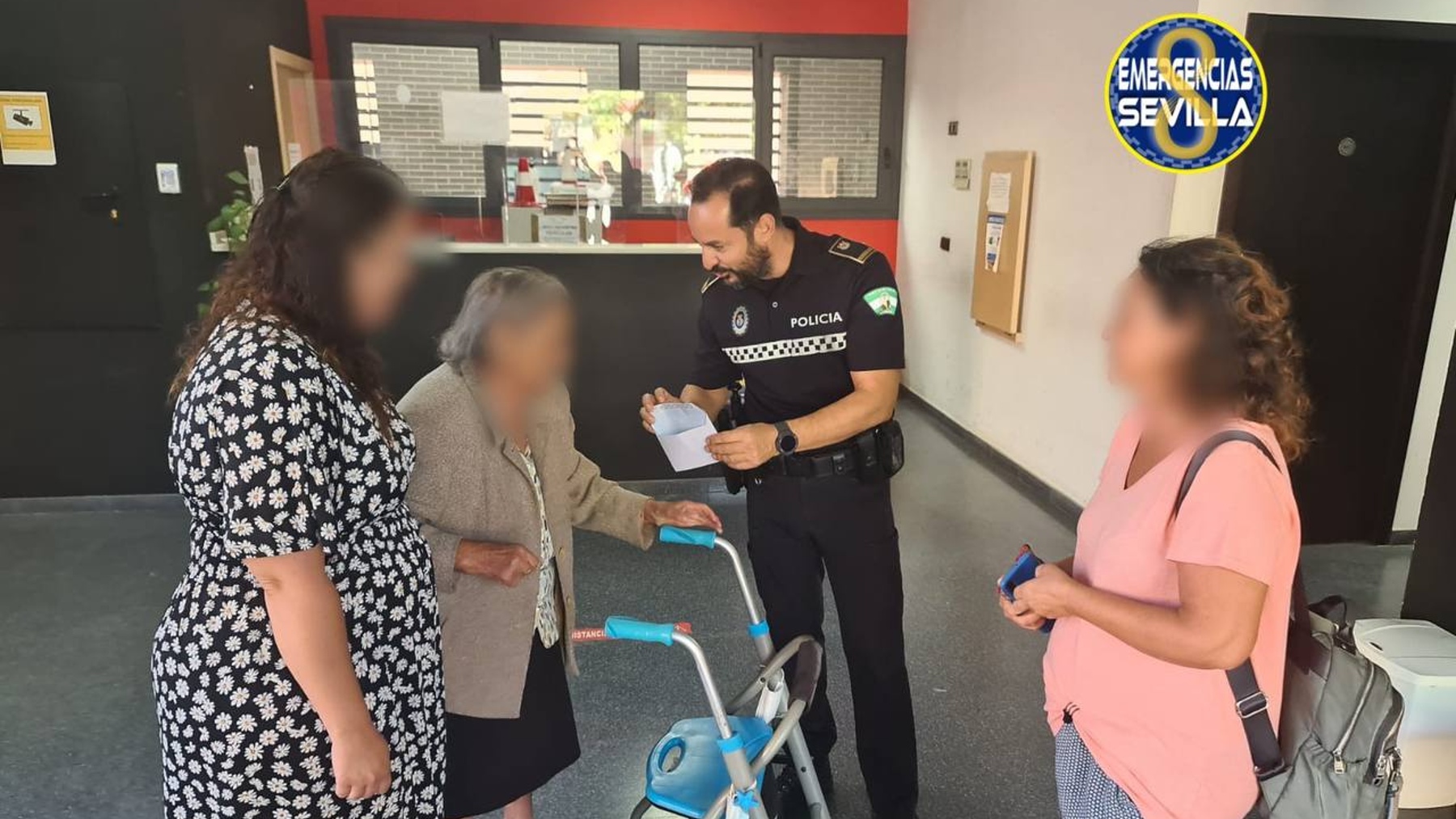 Un agente de la Policía Local de Sevilla hace entrega del sobre a la anciana.