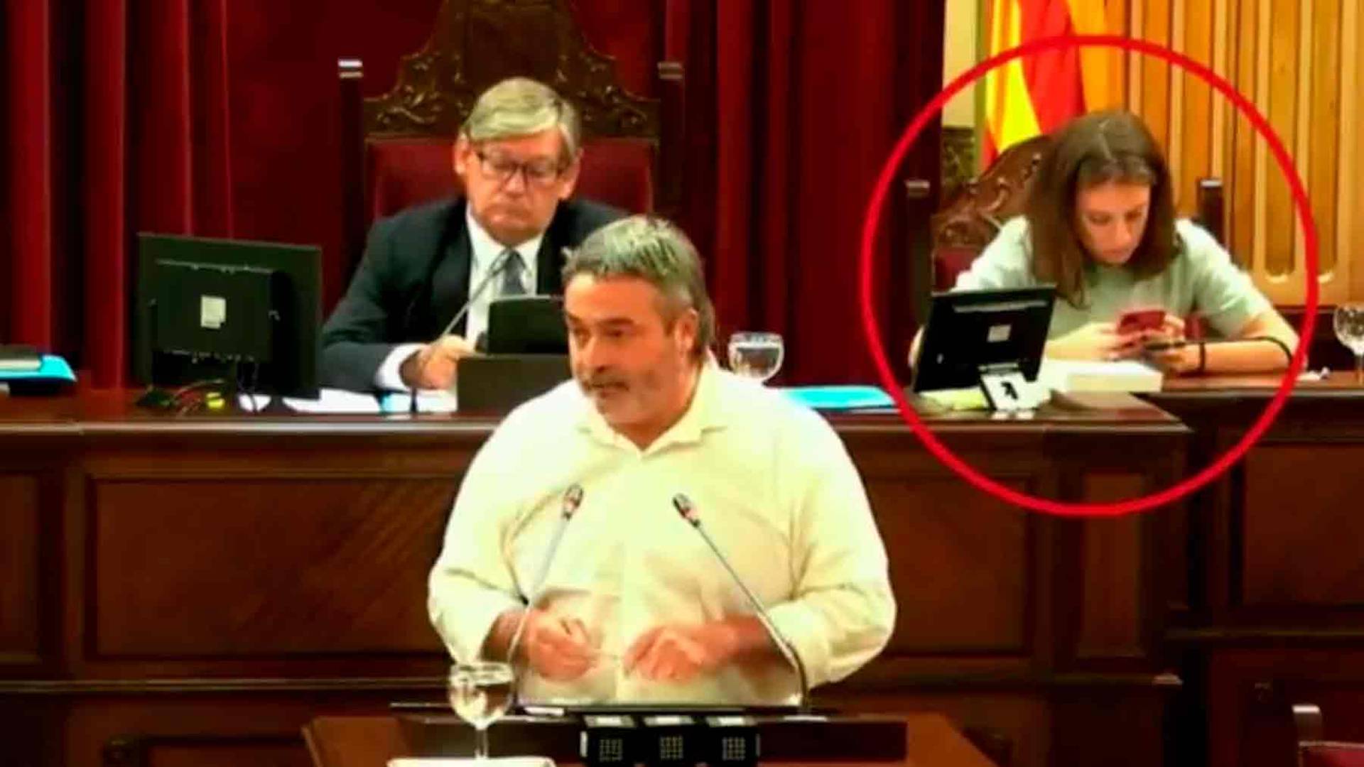Gloria Santiago con su móvil durante la intervención de un diputado de Més per Mallorca.