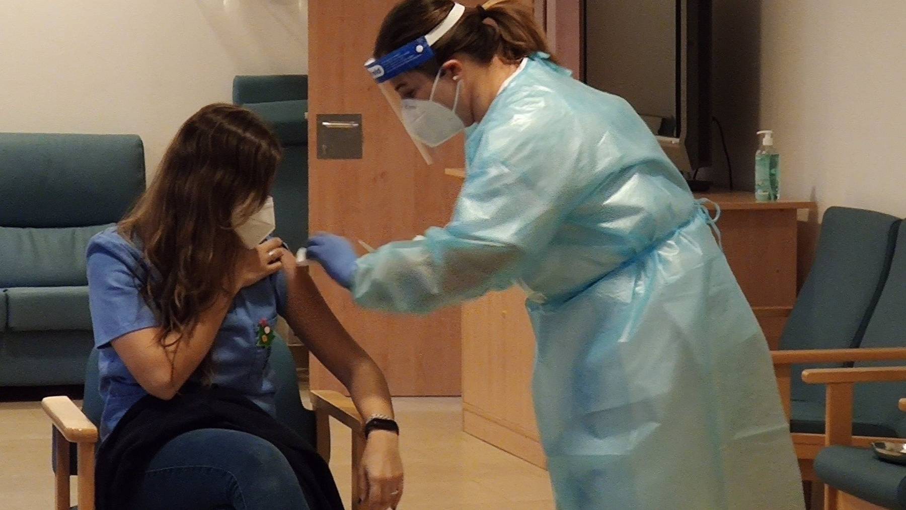 Una enfermera de una residencia de mayores recibe la vacuna contra la Covid-19.