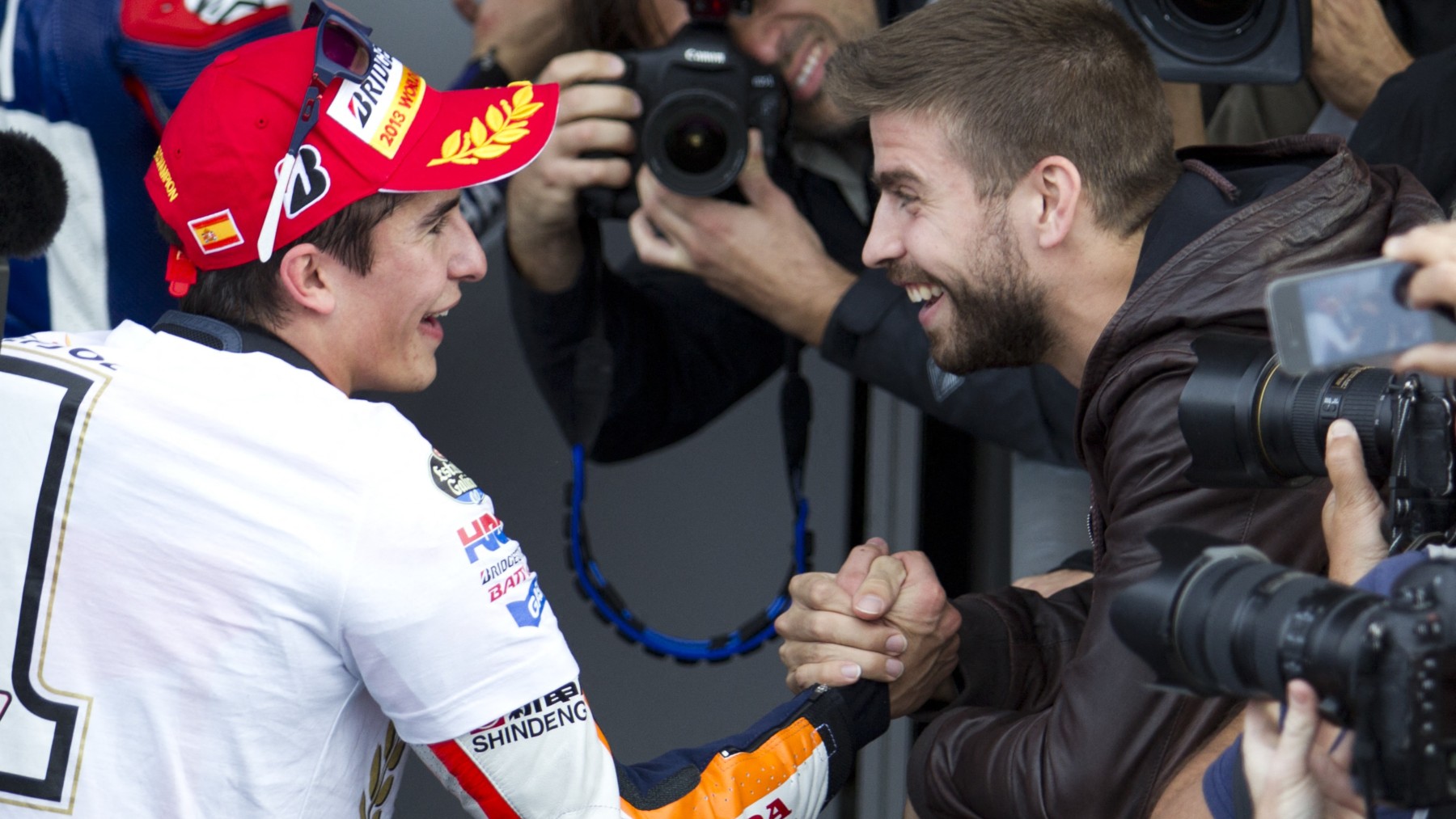 Márquez saluda a Piqué tras ganar su primer título de MotoGP en 2013. (AFP)