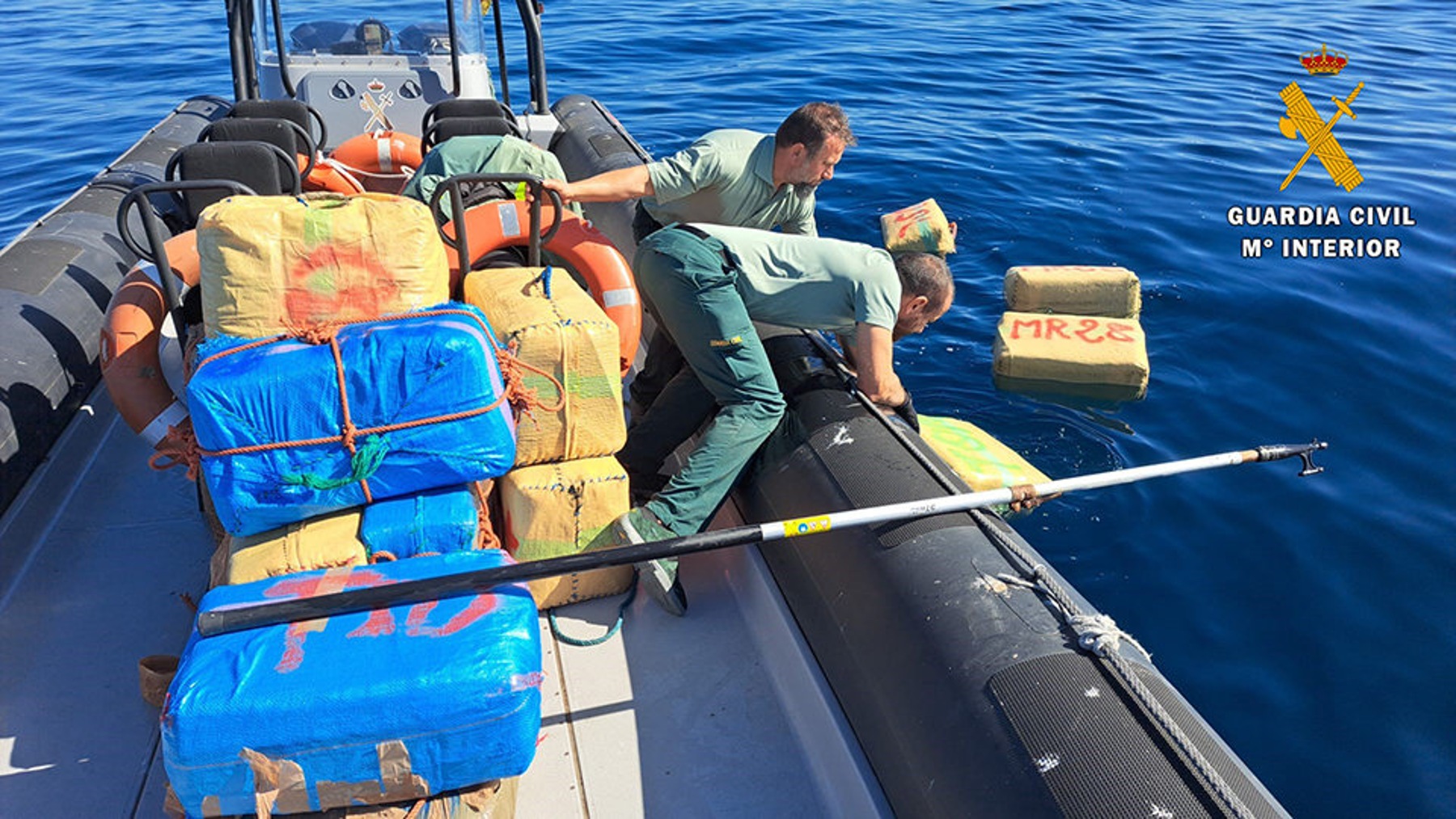 Agentes de la Guardia Civil recogen fardos de hachís en aguas del Estrecho (GC).