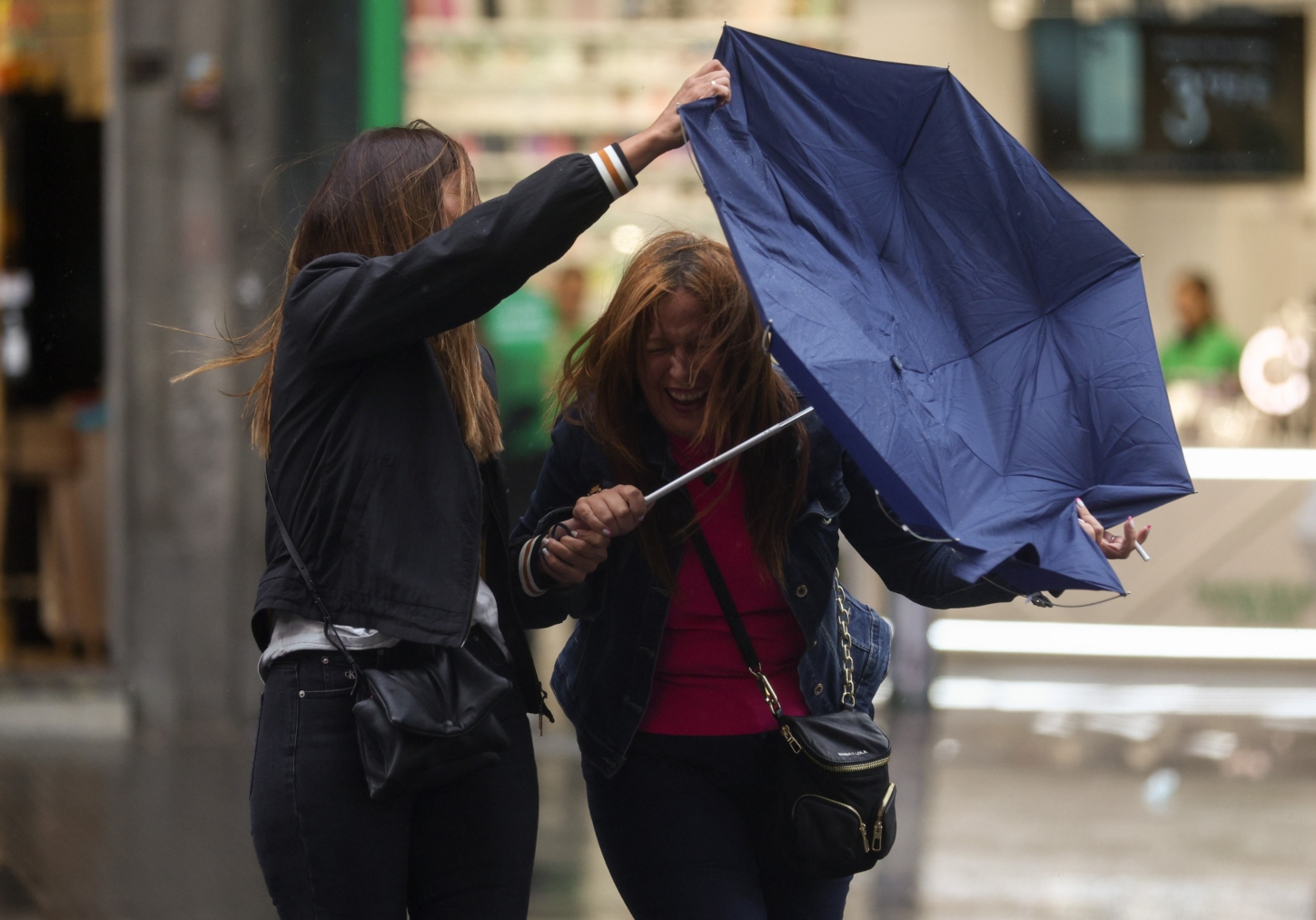 Dos jóvenes se protegen de la lluvia en Madrid (Foto:EP)