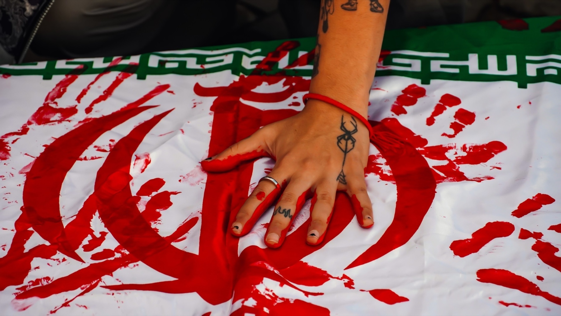 Bandera ensangrentada de Irán en una manifestación (EP)