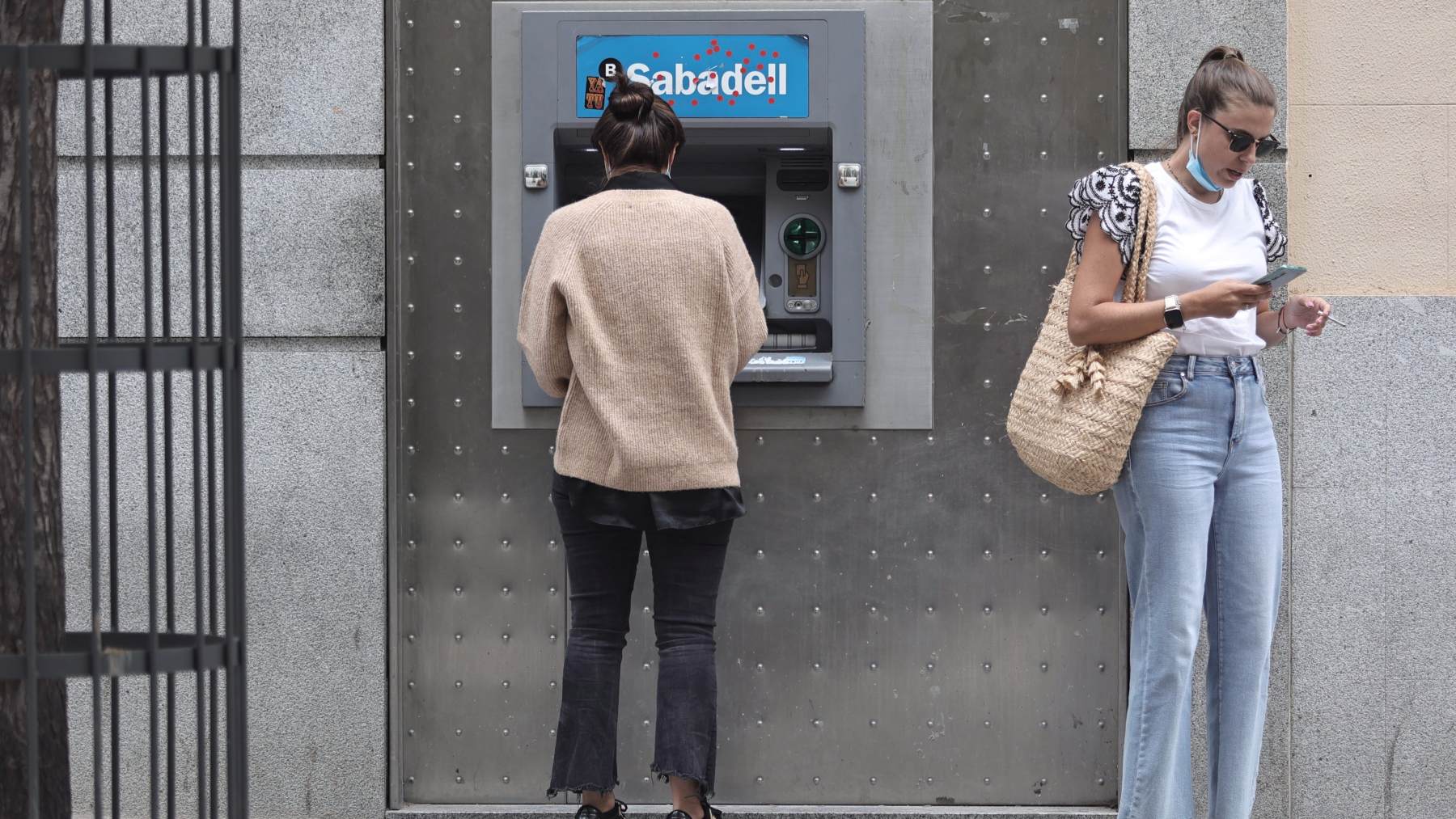 Dos mujeres en un cajero de Banco Sabadell. EP