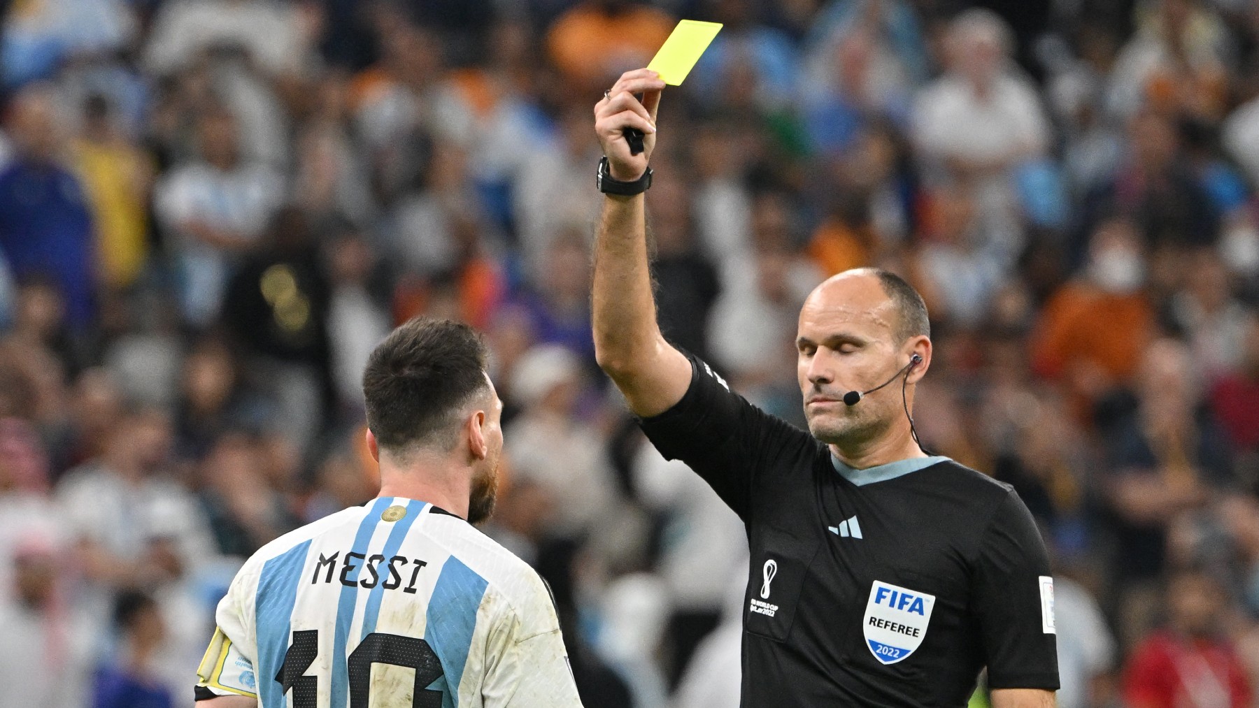 Mateu Lahoz le enseña una tarjeta amarilla a Messi. (AFP)