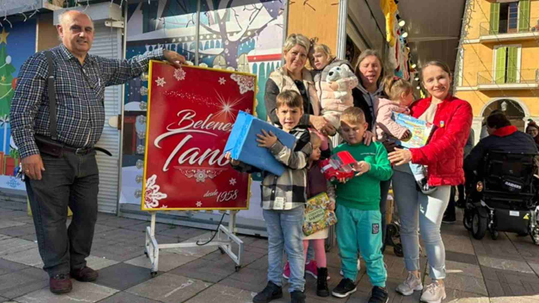 Tano González, propietario de Belenes Tano, junto a las familias ucranianas.