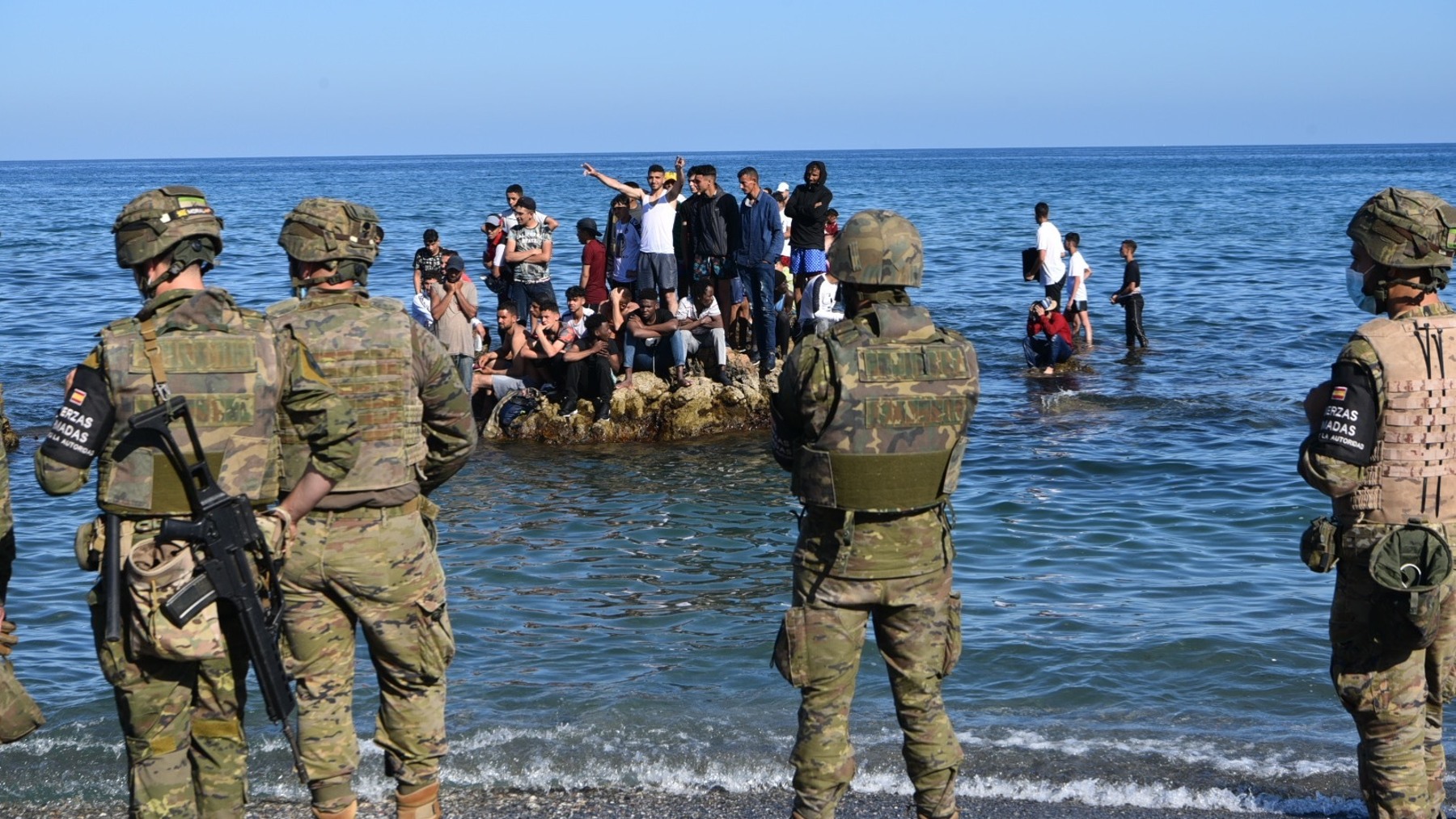 Militares frente a menores marroquíes llegados a Ceuta durante la invasión migratoria de mayo de 2021 (EUROPA PRESS).