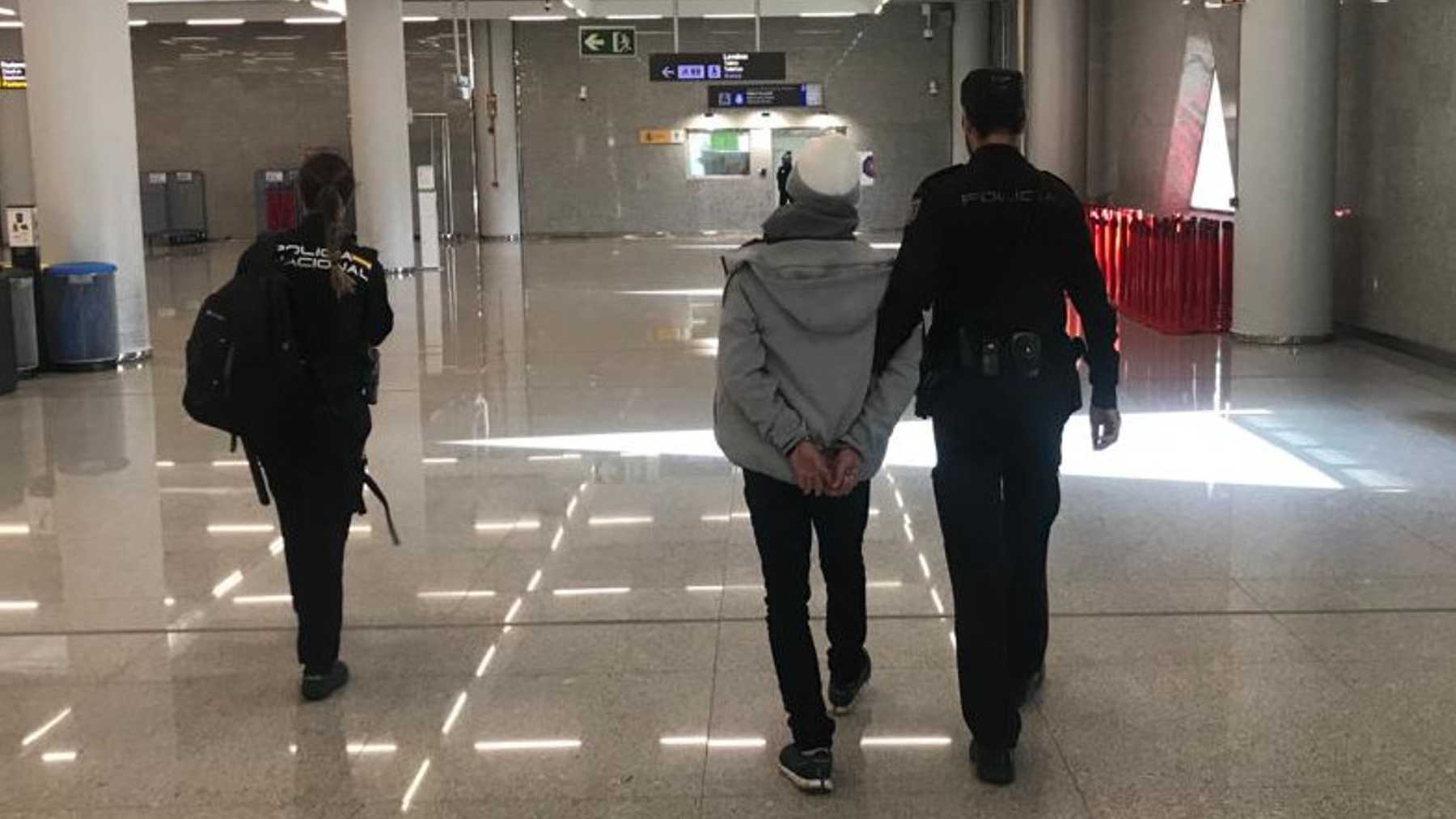 Agentes con el detenido esposado en el aeropuerto de Palma. POLICÍA NACIONAL