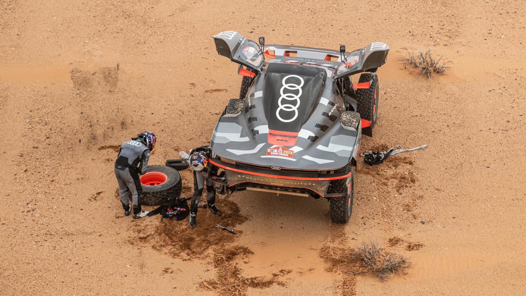 Carlos Sainz y Lucas Cruz arreglando los daños sufridos en el coche en la tercera etapa del Dakar. (dakar.com)
