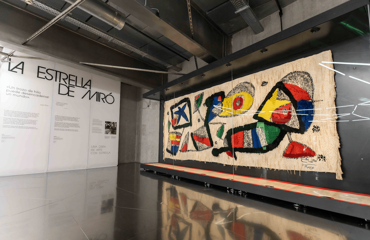 La estrella de Miró muestra el tapiz a los visitantes que llegan y se van del centro acompañado de plafones que cuentan la historia de la pieza.