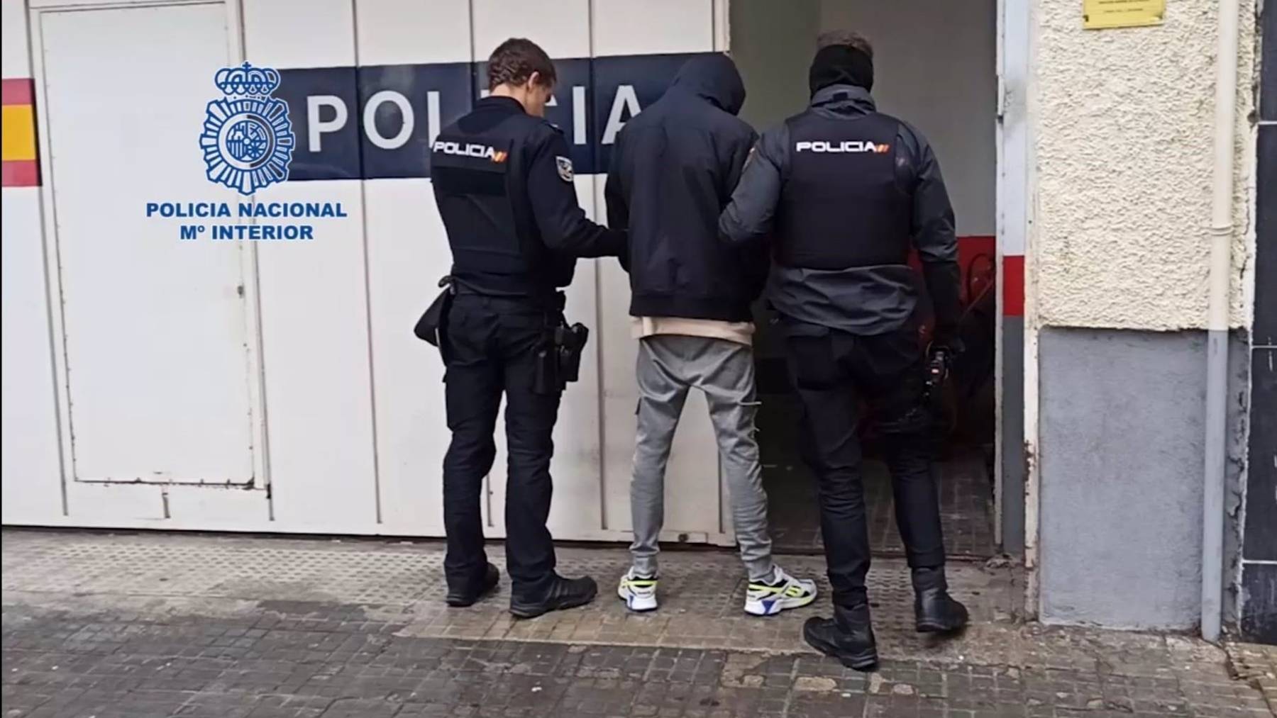 Agentes de la Policía Nacional con uno de los detenidos por una riña tumultuaria con lanzamientos de sillas y armas blancas en Palma.