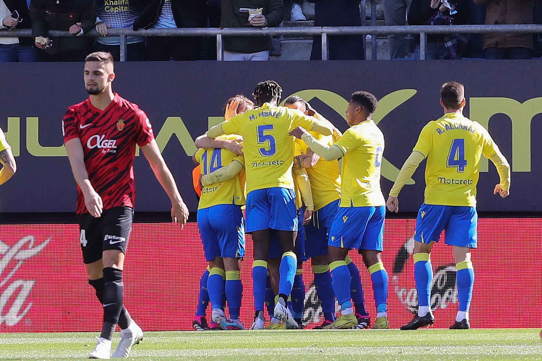 Los jugadores del Cádiz celebran un gol mientras Valjent se retira cabizbajo