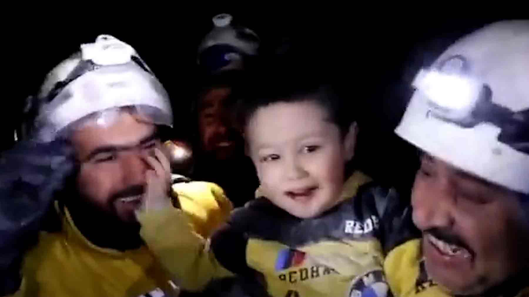 Un niño sonríe tras ser rescatado de los escombros