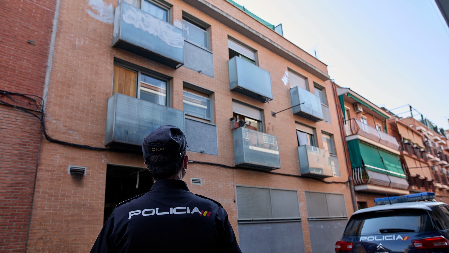 Un policía delante de un edificio de okupas en Madrid. (Foto: EP)
