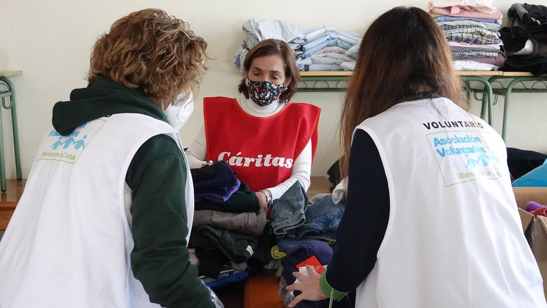 Voluntarias de Cáritas clasificando ropa para enviar a Ucrania.