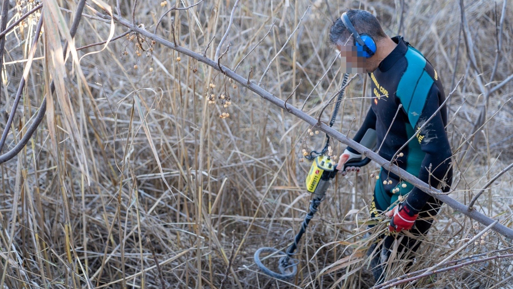 Un agente de la Guardia Civil busca el arma homicida en el arroyo Salado de El Rubio (EUROPA PRESS).